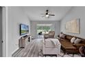 Inviting living room with modern gray floors, ceiling fan, and sliding doors to the outside patio at 1527 Braewick St, Winter Springs, FL 32708