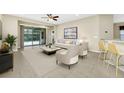Bright living room features neutral tones, stylish decor, and sliding doors to the lanai at 15366 Sandfield Loop, Winter Garden, FL 34787