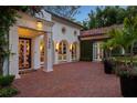 Grand home entrance with stone pillars, a decorative door, red brick, and lush landscaping details with lights at 1640 E Adams Dr, Maitland, FL 32751