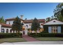 Elegant home exterior featuring a red-brick driveway, lush landscaping, and classic architectural design with a terracotta roof at 1640 E Adams Dr, Maitland, FL 32751