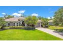 Charming single-story home with a well-manicured lawn, lovely landscaping, and a brick-paved driveway at 18108 Bellezza Dr, Orlando, FL 32820