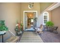 Inviting front porch with decor, seating, and a charming open door to welcome you home at 18108 Bellezza Dr, Orlando, FL 32820