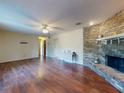 Spacious living room featuring wood floors, a brick fireplace, and a ceiling fan at 1872 N Akron Dr, Deltona, FL 32738