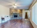 Open-concept living room showcasing a brick fireplace, wood floors, and natural light at 1872 N Akron Dr, Deltona, FL 32738