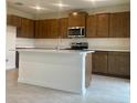 Modern kitchen featuring stainless steel appliances, a kitchen island, and ample cabinet space at 2013 Stone Wall Ct, Lake Hamilton, FL 33851