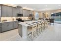 Stunning kitchen features an oversized island, stainless appliances and modern grey cabinetry at 2332 Salty Winds Way, Kissimmee, FL 34747