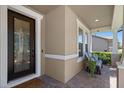 Inviting front porch with brick flooring, seating, and a decorative glass front door with a white trim at 2614 Mead Ave, St Cloud, FL 34771