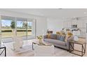 Open-concept living area with stylish furnishings, tile flooring, and a large sliding glass door at 2770 Sweet Acacia Dr, Clermont, FL 34711