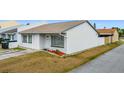 Charming home featuring white stucco, neutral roof, tidy front yard, and welcome decor at 2803 Charing Cross Way, Orlando, FL 32837