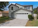 Two-story home with a two-car garage and well-maintained front yard and landscaping at 2806 Polson Dr, Kissimmee, FL 34758