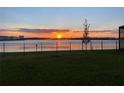 Beautiful sunset over the water, seen from a grassy backyard with a black metal fence at 2926 Wordsmith Rd, Kissimmee, FL 34746