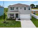 Two-story home featuring a well-maintained lawn, covered porch with bench, a two-car garage and play set at 3033 Beau Loop, Tavares, FL 32778