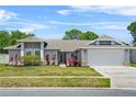 Inviting single-story home featuring a two-car garage and beautifully manicured front yard at 3137 Timucua Cir, Orlando, FL 32837