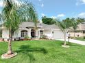 Charming single-story home with a well-manicured lawn, palm trees, and a welcoming front entrance at 3534 Woodley Park Pl, Oviedo, FL 32765
