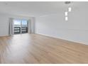 Bright, open living room featuring hardwood floors, pendant lighting, and sliding glass doors at 3606 S Peninsula Dr # 707, Port Orange, FL 32127