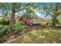 Landscaped front yard with mature trees, colorful plantings, and a well-manicured lawn at 4219 Lillian Hall Ln, Orlando, FL 32812