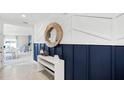 Stylish entryway with tile flooring, decorative mirror, a white console table, and elegant blue wainscoting at 4622 Barberry Ave, Lakeland, FL 33811