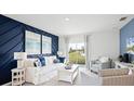 Bright living room boasts a decorative blue accent wall, comfortable seating, and sliding glass doors to the outdoors at 4622 Barberry Ave, Lakeland, FL 33811