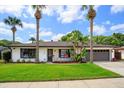 Well-maintained single-story house with landscaped front yard, mature trees, and an attached garage at 5162 Tellson Pl, Orlando, FL 32812
