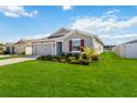 Charming single-story home with a well-manicured lawn, attached garage, and red accent shutters at 5347 Travertine St, Mount Dora, FL 32757