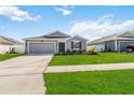 Charming single-story home with a well-manicured lawn, attached garage, and red accent shutters at 5347 Travertine St, Mount Dora, FL 32757