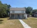 Charming two-story home featuring a covered front porch and a well-maintained lawn at 613 Michigan Ave, St Cloud, FL 34769
