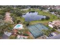 Beautiful aerial view of the community amenities including a pool, tennis courts, and a picturesque pond at 688 W Cranes Cir, Altamonte Springs, FL 32701