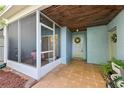 Covered entrance featuring tiled flooring, screened enclosure, and outdoor garden access at 702 Glasgow Ct, Winter Springs, FL 32708