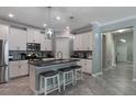 Modern kitchen with stainless steel appliances, island with seating, and stylish pendant lighting at 7605 Lake Hancock Blvd, Winter Garden, FL 34787