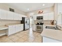 Well-equipped kitchen featuring stainless steel appliances, white cabinetry, and tile flooring at 812 Seneca Meadows Rd, Winter Springs, FL 32708
