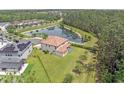 Aerial view of the backyard featuring a pond, grass and fence surrounding a two-story home at 8478 Elba Isle Ct, Windermere, FL 34786