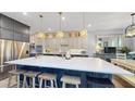 Spacious kitchen featuring a large island, modern appliances, custom cabinets, and designer lighting at 8478 Elba Isle Ct, Windermere, FL 34786