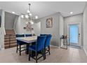 Stylish dining area featuring a marble table, blue chairs, elegant lighting and decor at 9009 Savannah Julip Ln, Orlando, FL 32832