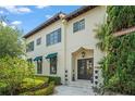 Elegant front entrance with a tile walkway, lush landscaping, and a stylish, arched doorway at 9730 Lounsberry Cir, Golden Oak, FL 32836
