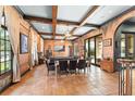 Open-concept living and dining area with exposed beams, unique wall texture, and ample seating at 9730 Lounsberry Cir, Golden Oak, FL 32836