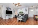 Bright living room with wood-look flooring, a ceiling fan, and cozy seating arrangement with throw pillows at 1037 Abagail Dr, Deltona, FL 32725