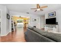 Inviting living room with wood-look floors, a ceiling fan, and an open layout flowing into the dining area at 1037 Abagail Dr, Deltona, FL 32725