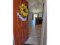 Inviting entryway with decorative wreath, leading into open-concept living area with tile flooring and kitchen view at 119 Stewart Lake Loop, Groveland, FL 34736