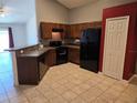 Functional kitchen with black appliances, ample cabinet space, and a convenient breakfast bar at 119 Stewart Lake Loop, Groveland, FL 34736
