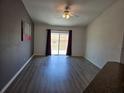 Bright living room with vinyl flooring, large sliding glass doors, and stylish accent wall paint at 119 Stewart Lake Loop, Groveland, FL 34736