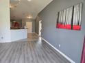 Open-concept living area with vaulted ceilings and light gray wood-look flooring throughout at 119 Stewart Lake Loop, Groveland, FL 34736