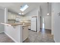 Bright eat-in kitchen with skylight, tile flooring, and white appliances at 1240 Pin Oak Dr, Apopka, FL 32703
