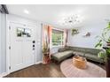 Bright living room features hardwood floors, a cozy green sectional, and stylish decor at 1421 N Hampton Ave, Orlando, FL 32803