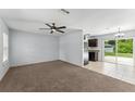 Inviting living room with a ceiling fan, and access to a tiled dining area and kitchen at 14878 Se 32Nd Ter, Summerfield, FL 34491