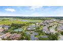 Aerial view of a community with a tennis court, a community pool, and ponds and lakes at 15242 Heron Hideaway Cir, Winter Garden, FL 34787