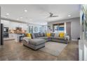 Open-concept living room showcases a large sectional, tile flooring, and flows into a modern kitchen at 15443 Sugarcup Ct, Orlando, FL 32828