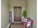 Inviting front porch with a decorative wreath, charming bench, and a welcoming atmosphere at 1880 Perch Hammock Loop, Groveland, FL 34736