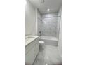 Modern bathroom featuring a tub with shower, marble tile, and contemporary vanity at 2009 Stone Wall Ct, Lake Hamilton, FL 33851