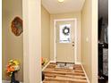 Welcoming entryway with wood-look flooring, a decorative wreath, and neutral paint, offering a warm welcome at 2102 Urbana Ave, Deltona, FL 32725