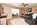 Cozy living room featuring a stone fireplace, large bay window, and comfortable seating at 2102 Urbana Ave, Deltona, FL 32725